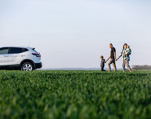 young-family-with-kids-travelling-by-car-stopped-field.jpg