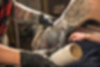 tattoo-artist-wrapping-client-s-arm-in-plastic-clingfilm-to-encourage-tattoo-healing.jpg