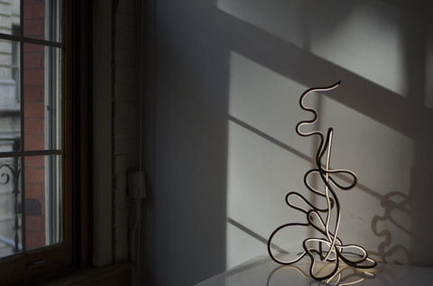 There are two major categories of our new work, Fluid forms, and what we call Ink Forms.  

The later is a representation of literal ink on paper, as a sketch or freehand expression of a form, that ends in the unrefined motion of a line in light.  The Ink Forms are very difficult to make, as the complexity of compound curves and balance is thus subject to the rigidity of the LED's.  
As all of these forms are made without the use of machines or computers (on purpose) it has taken years to perfect this seamless un-compromised, sculptural, continuous light.  

As you may know the light itself is a seamless fluid form, with no detection of individual LED's.  The effect, regardless of the Fluid Forms  or Ink Forms, is that of a light drawing suspended in space.
-Marcus Tremonto