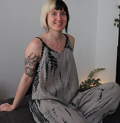 Smiling massage therapist sitting on a massage table