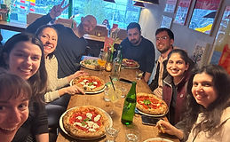 Selfie of a group of people gathering in a pizza place in amsterdam after a yoga class