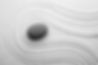 Grey stone on sand with pattern, top view. Zen, meditation, harmony.jpg