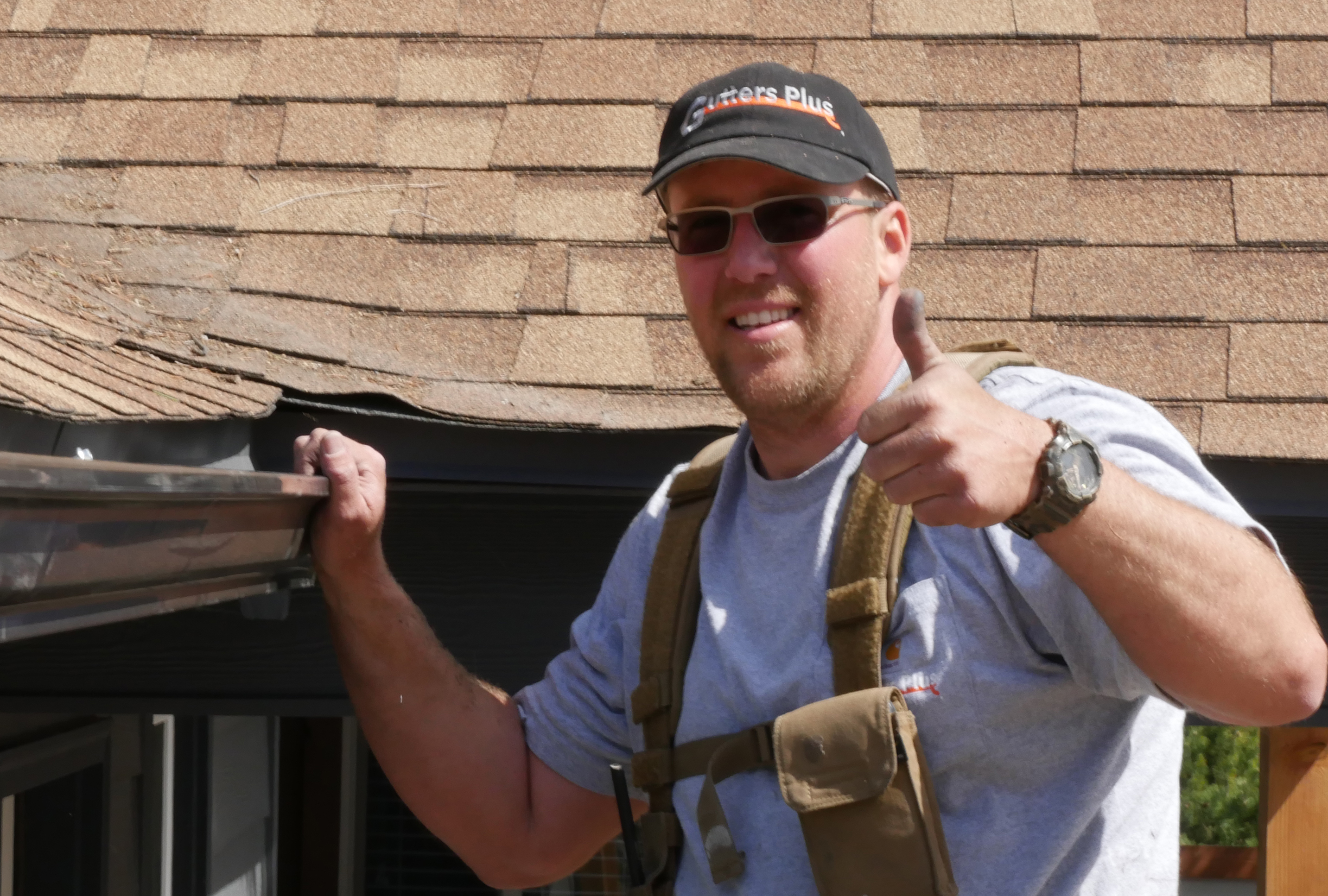 Gutters Plus owner Paul Phinney cleaning and inspecting gutters on a Bend, Oregon roof