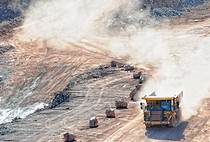 A huge truck moves through an open pit mine