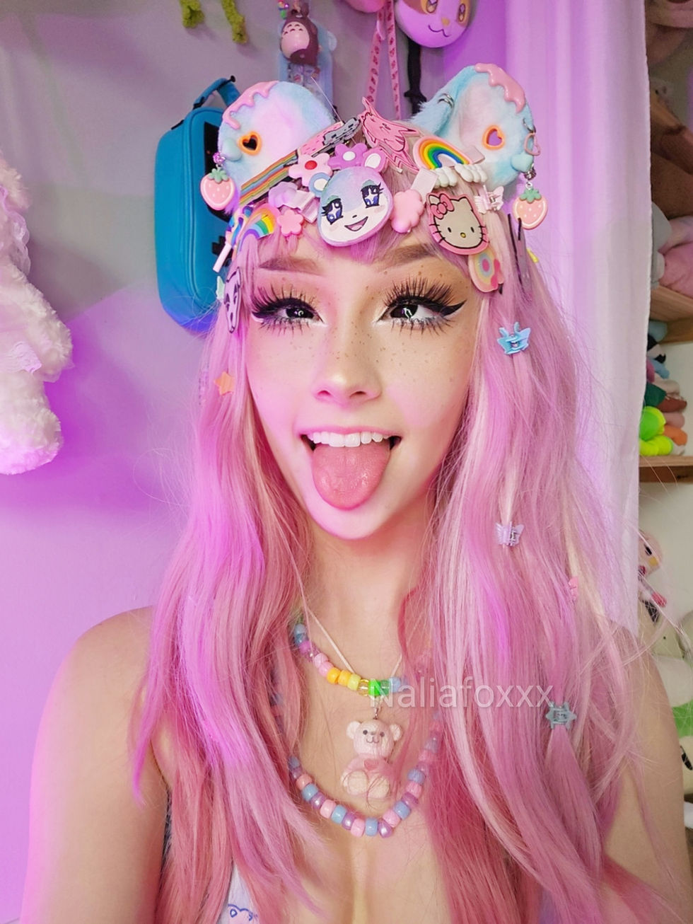 a girl with pink hair is wearing a hello kitty headband
