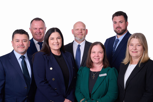 Corporate leadership team portrait of seven professionals in business suits against a white background https://www.brucerobinsonphotography.com.au/people