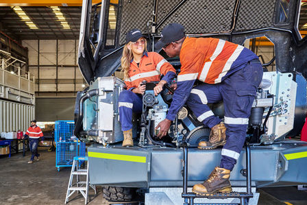 Liebherr technicians inspecting a machine inside a workshop. Two Liebherr technicians working together on heavy equipment inside a Sydney workshop. Liebherr service technicians carrying out inspection and maintenance on heavy machinery at a Sydney service facility. Two Liebherr technicians collaborating while inspecting heavy machinery in a Sydney workshop, highlighting teamwork, safety, and technical expertise.