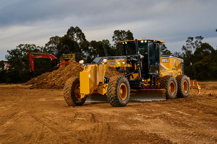 Bell motor grader operating on a dirt training ground. Bell motor grader imported to Australia by Hitachi, photographed at the IPOTS training ground in the Hunter Valley. Bell grader imported by Hitachi Australia at the IPOTS training facility in the Hunter Valley. A Bell motor grader imported to Australia by Hitachi, working on a training site at IPOTS in the Hunter Valley. Bell motor grader supplied by Hitachi Australia during operator training at the IPOTS facility in the Hunter Valley.
