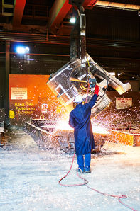 Foundry worker pouring molten metal during an industrial casting process. A foundry worker overseeing the pouring of molten metal at Bradken Foundry in Brisbane, with sparks flying during the casting process. Molten metal being poured at Bradken Foundry, Brisbane, as a foundry worker controls the casting process amid sparks and heat. A foundry worker operating overhead equipment as molten metal is poured at Bradken Foundry in Brisbane, capturing the intensity and precision of industrial manufacturing. Industrial casting in progress at Bradken Foundry, Brisbane, with molten metal pouring from a suspended ladle under controlled conditions.