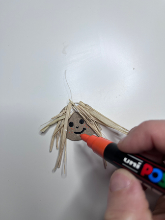 dessiner le visage de l'épouvantail à l'aide de marqueurs peinture (type posca)