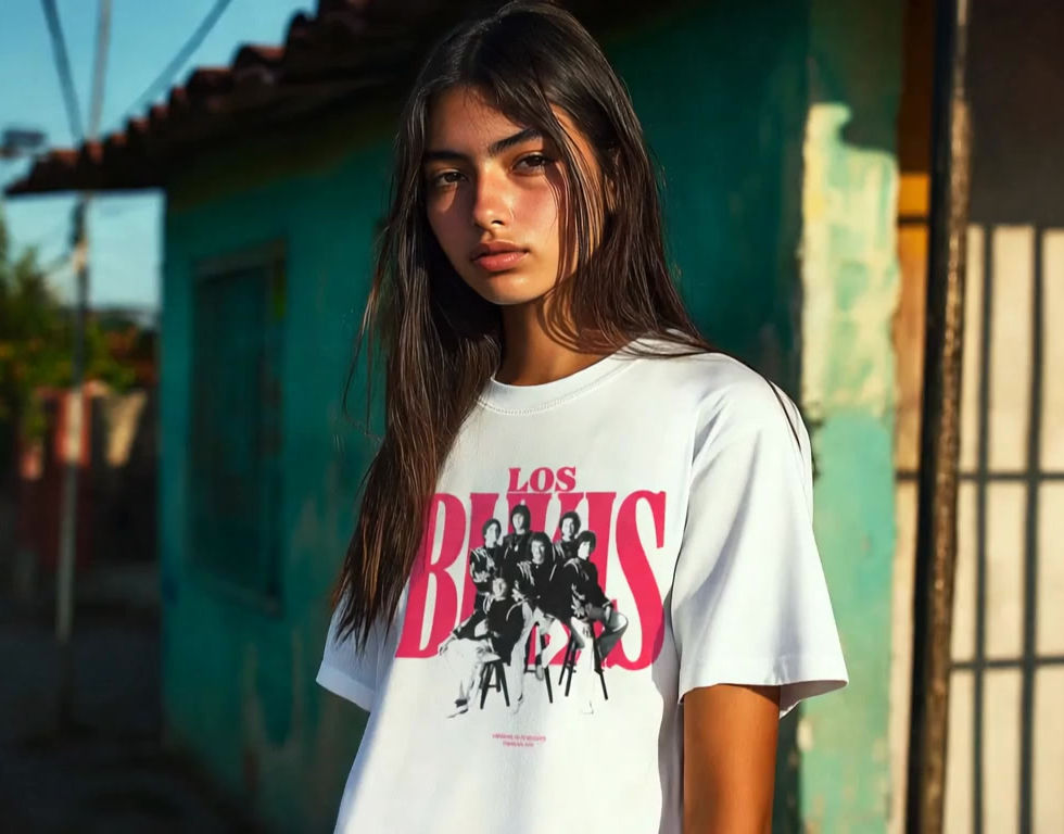 Young man wearing black Los Bukis vintage T-shirt with white 'BKS' logo, standing in turquoise alley