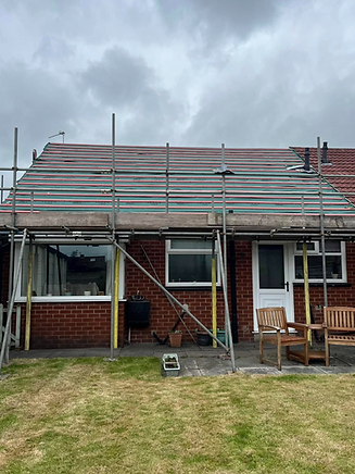 Single-story brick house with scaffolding on the roof