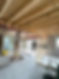 An unfinished construction site with exposed beams, framing in progress