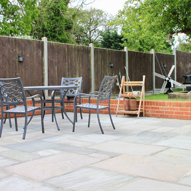 Outdoor patio scene featuring a metal table and chairs set on stone tiles
