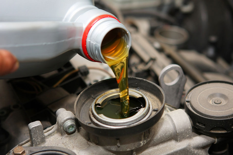 close up of pouring oil into a car engine