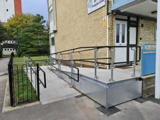 Wheelchair-accessible ramp with handrails leading to a building entrance