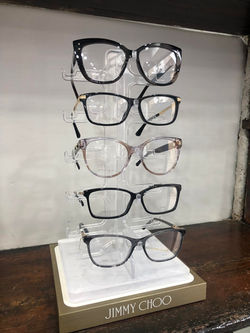 Jimmy Choo eyeglasses displayed on a sleek stand
