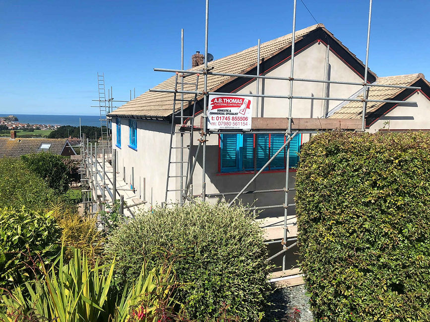 A residential property surrounded by complex metal scaffolding pipes erected for high-elevation external renovations