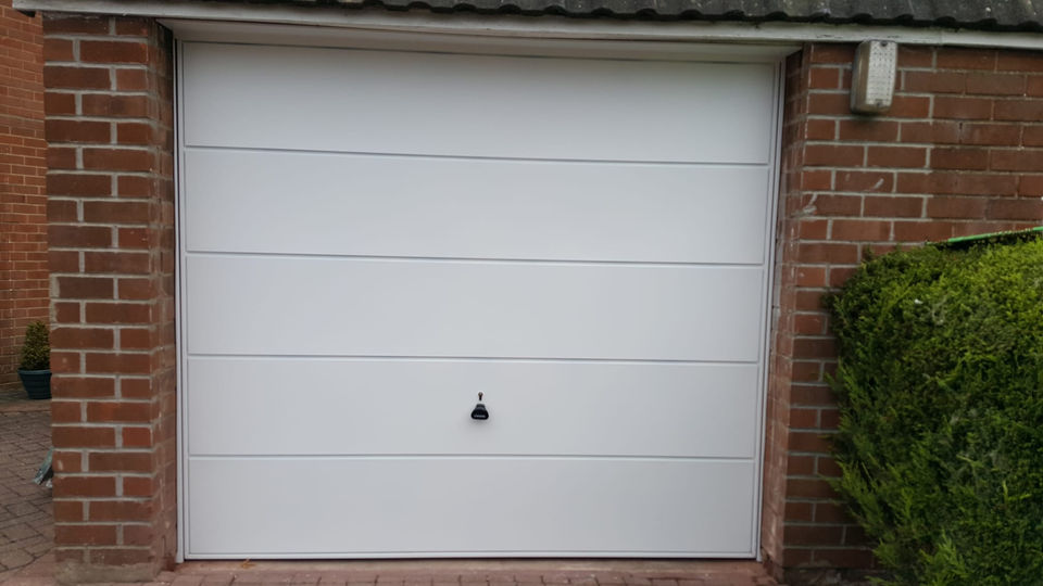 View of a white door of a garage with a handle