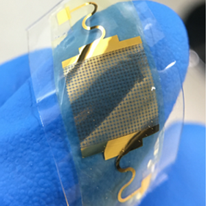 Gloved fingers gently holding a flexible transparent film circuit board asset
