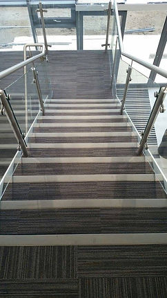 A modern staircase with striped carpet treads