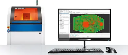 Computer monitor displaying green circuit layout alongside desktop prototyping system