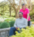 Smiling man in wheelchair with a happy female carer in a park