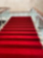 A grand staircase covered with a vibrant red carpet