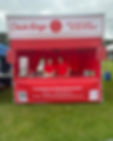 A red food stall tent for "Chick Kings" with a slogan and contact info displayed, and staff wearing red uniforms.