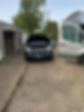 A black car outside the house with an open hood