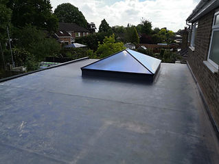 Flat rooftop with a pyramid-shaped glass skylight centred