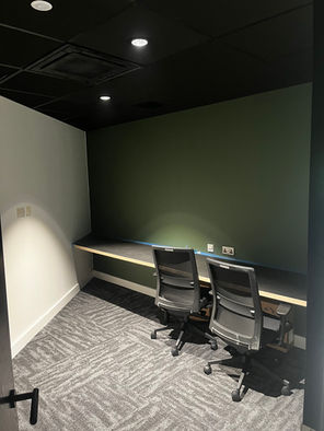 A room featuring two chairs positioned around a desk