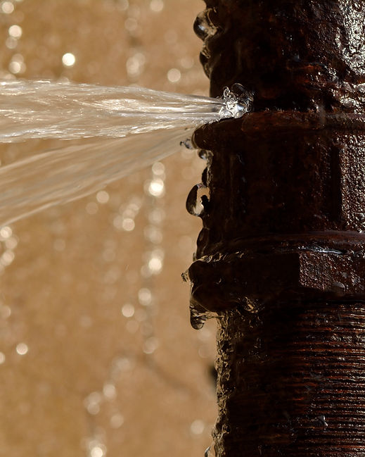 Water spraying under high pressure from a cracked metal pipe