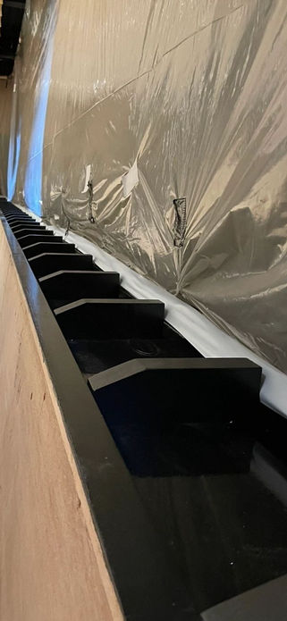 A long row of black metal benches arranged neatly in a spacious room