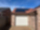 A brick house with a red tiled roof features solar panels on one side
