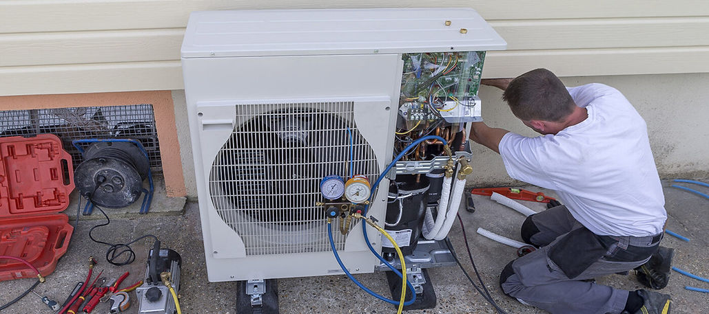 Technician opening an outdoor heat pump unit for repairs