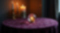 Dark mystical scene featuring a burning candle and crystal ball