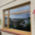 Large wood-effect window with a transom and reflection