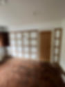 A room under renovation with a wooden floor and white walls
