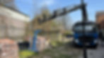 A crane lifting bricks from a pile at a construction site