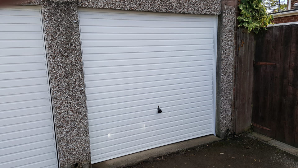 View of 2 white garage doors, which are locked