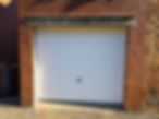 Close-up view of a white garage door on the side of the entrance of the house