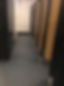 A row of public toilet cubicles with dark grey flooring
