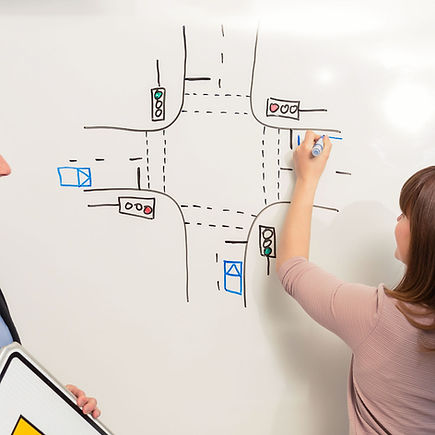 Instructor drawing a road junction diagram on a whiteboard