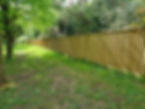 A long wooden fence runs alongside a grassy path