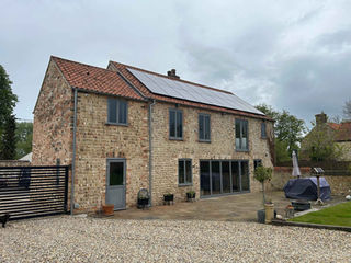 A modern, brick house with solar panels and large windows