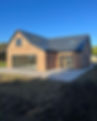 A newly built brick house with a dark roof