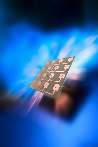 Small square integrated silicon chip component glowing against abstract blue light