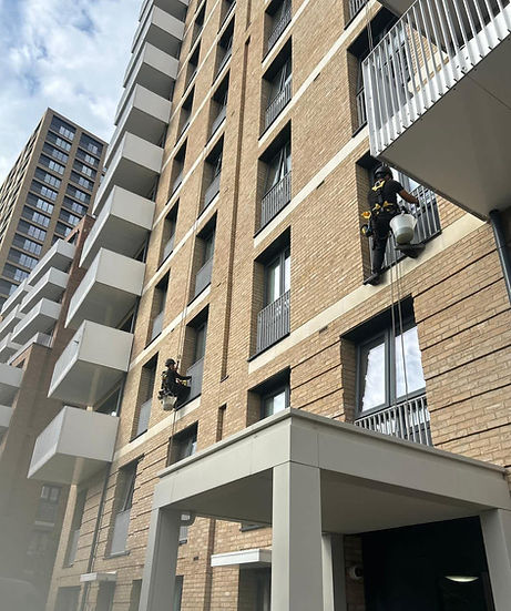 Commercial window cleaning professionals outside a building in London.