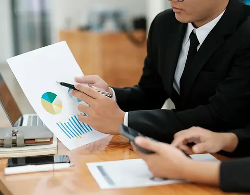 Two people in suits review graphs and charts